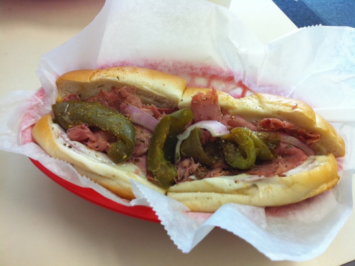 A cold-cut sub sandwich with banana peppers, red onion and provolone